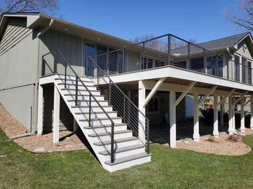A house with a large deck and stairs leading up to it.