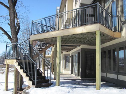 A house with a balcony and stairs in the snow