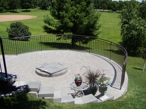 A patio with a fence around it and a fire pit