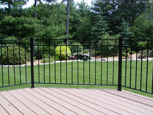 A wooden deck with a metal fence surrounding it