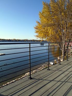 A deck with a railing overlooking a body of water.