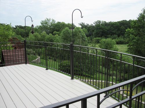 A deck with a railing and trees in the background