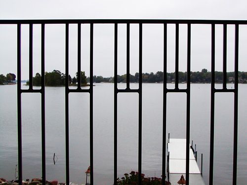 A view of a lake through a black railing