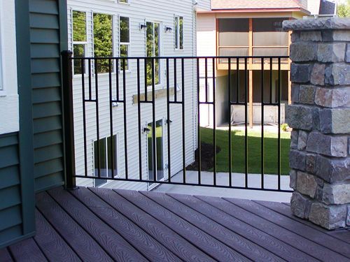 A deck with a metal railing and a stone pillar