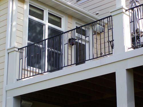 A balcony on the side of a house with a black railing