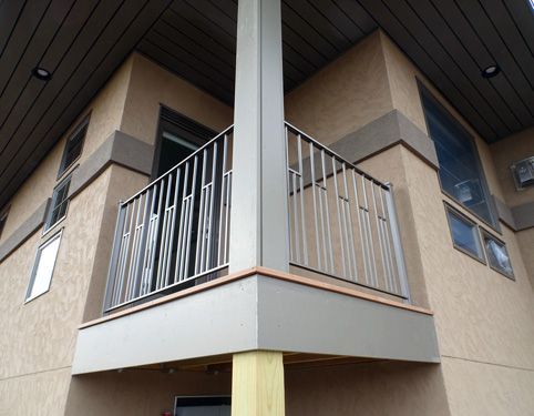 A balcony on the side of a building with a metal railing