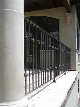 A close up of a wrought iron railing on a balcony.
