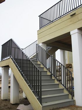 A set of stairs leading up to a deck with a metal railing