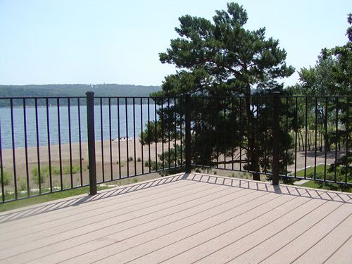 A deck with a railing overlooking a body of water