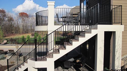 A set of stairs leading up to a balcony with a metal railing.