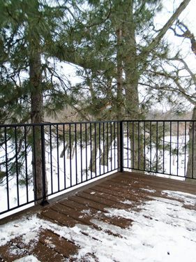 A balcony with a railing overlooking a snowy forest.
