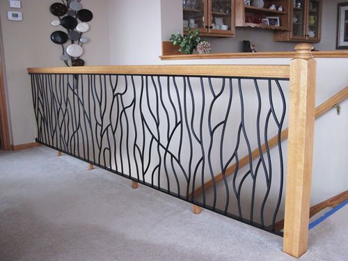 A staircase with a wrought iron railing and a wooden handrail