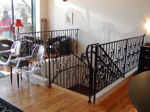A staircase with a wrought iron railing in a living room