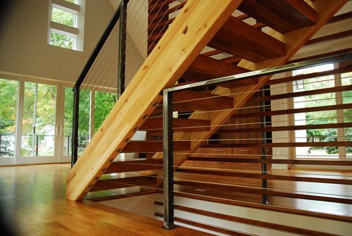 A wooden staircase with a metal railing in a house