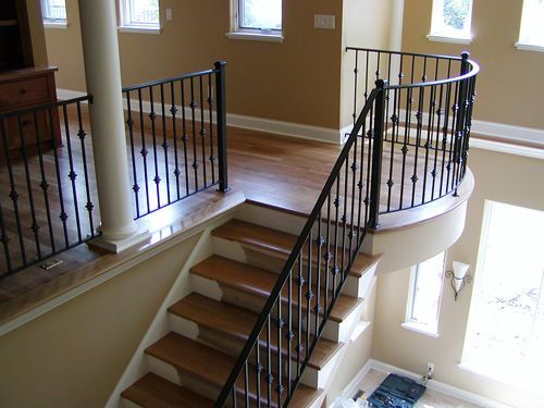A staircase with a wrought iron railing and wooden steps