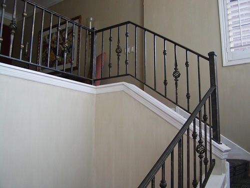 A staircase with a wrought iron railing in a house