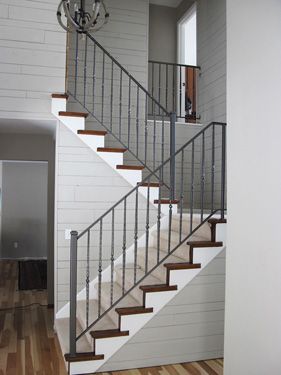 A staircase with wooden steps and a metal railing in a house.