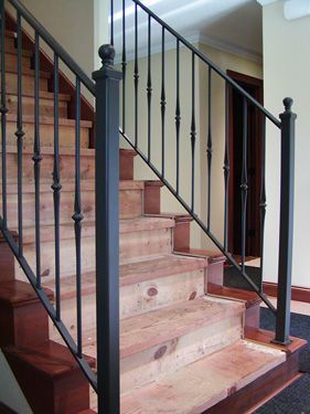 A wooden staircase with a metal railing in a house.