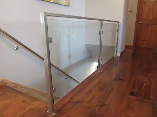 A staircase with a glass railing and a wooden floor.