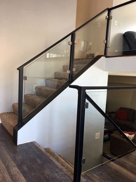 A staircase with a glass railing in a living room.