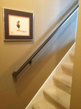 A staircase with a picture on the wall above it
