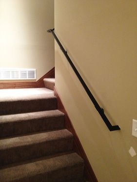A staircase with a black railing and carpeted steps in a house.