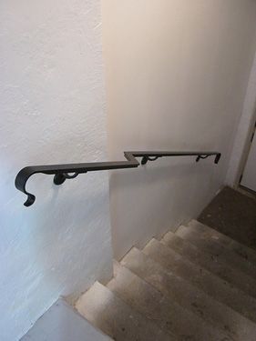 A staircase with a metal railing on the side of it.