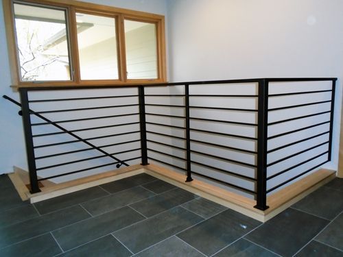 A staircase with a black railing and a window