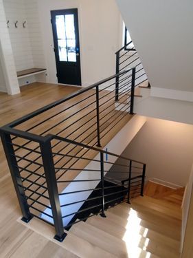 A staircase with a black railing and wooden steps
