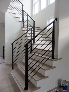 A staircase with a black railing and wooden steps