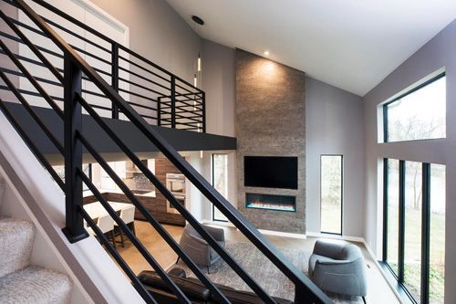 A living room with a staircase leading to the second floor.