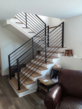 A staircase with a black railing in a living room