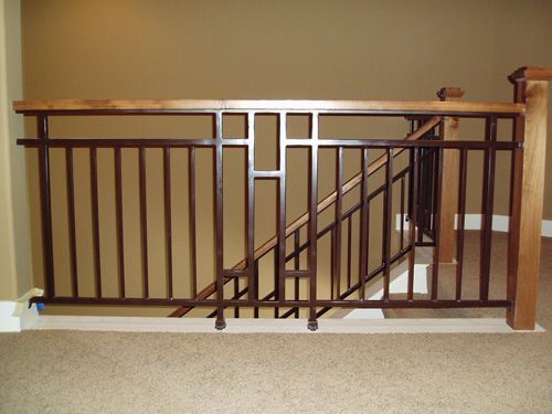A staircase with a metal railing and a wooden handrail