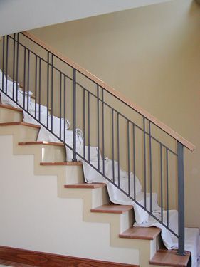 A staircase with a metal railing and wooden steps