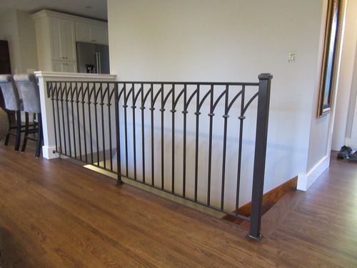 A wrought iron railing on a staircase in a house.