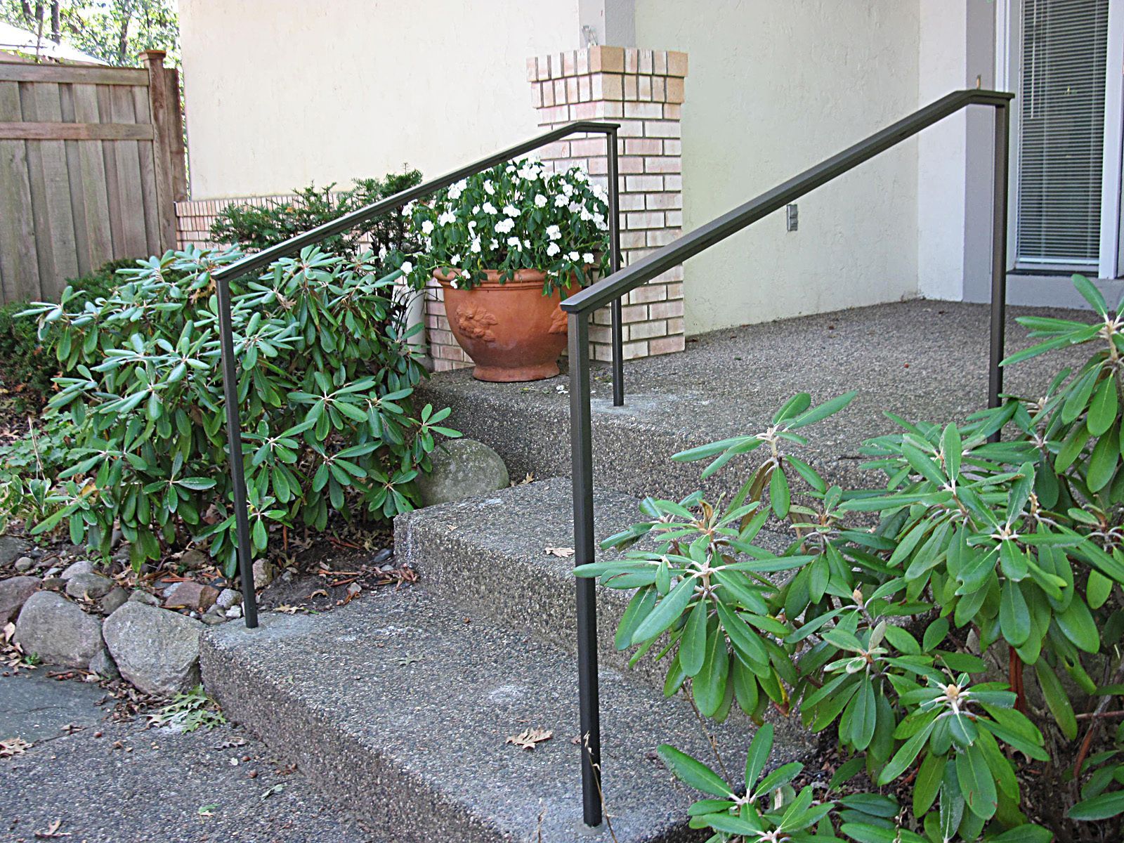 A wooden fence leading to a stone walkway and stairs