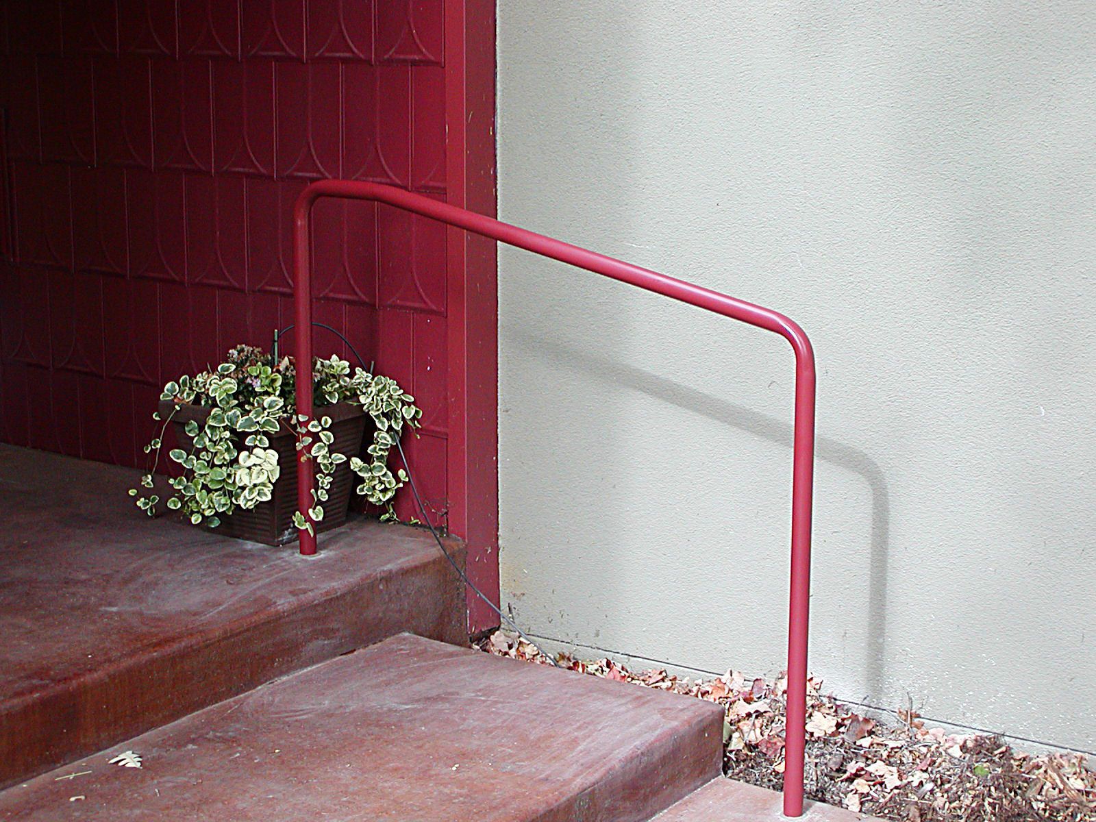 A white house with stairs and a metal railing