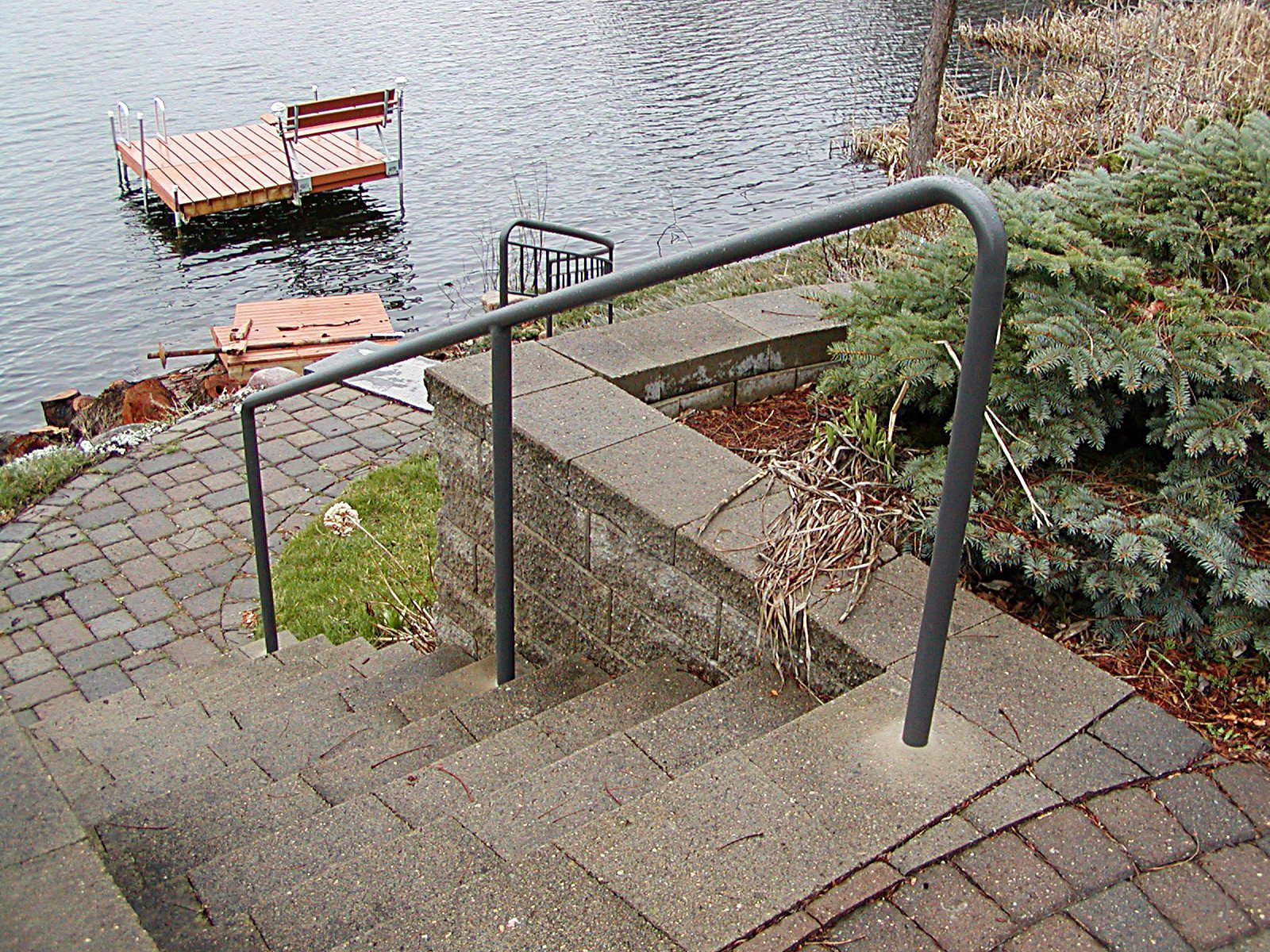 A black brick building with stairs and a railing