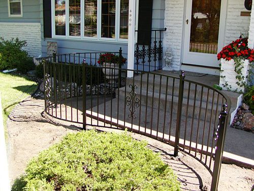A wrought iron fence is in front of a house