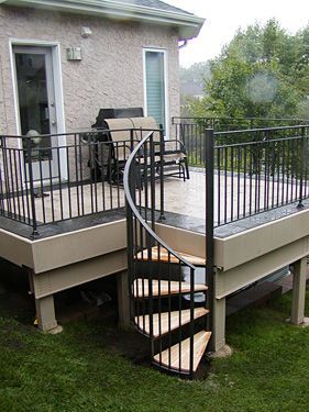 A deck with a spiral staircase leading up to it.