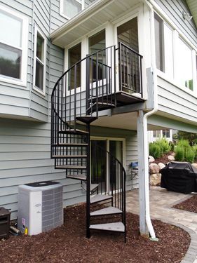 A spiral staircase on the side of a house