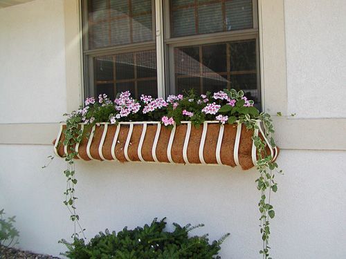A window box with pink and white flowers in it