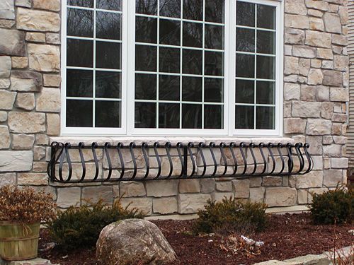 A window with a wrought iron fence around it