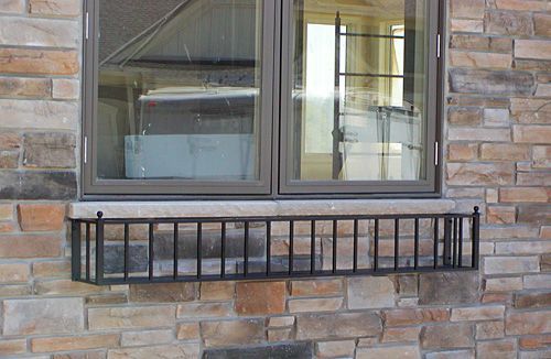 A brick wall with a window and a planter on it
