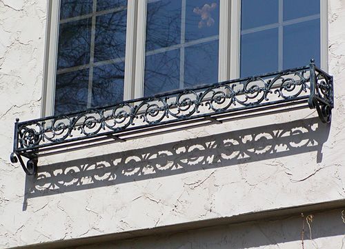 A window with a wrought iron railing on it
