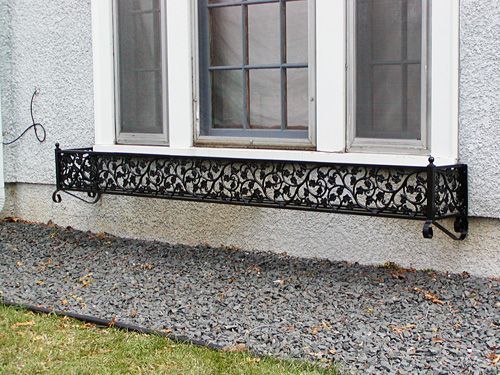 A window box is attached to the side of a house.