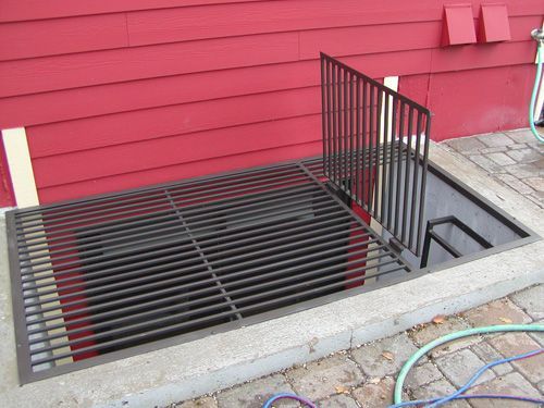 A red house with a black grille on the side of it