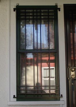 A window with bars on it and a door in the background.