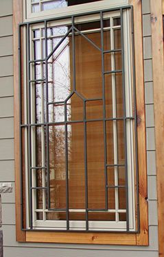 A window with a metal grill on it is on a house.