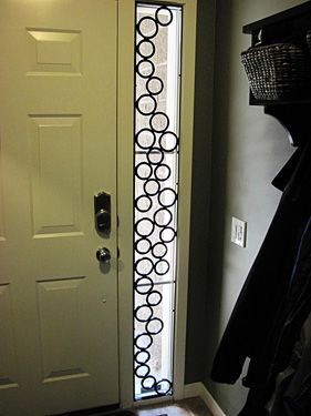 A white door with a stained glass window in a hallway.